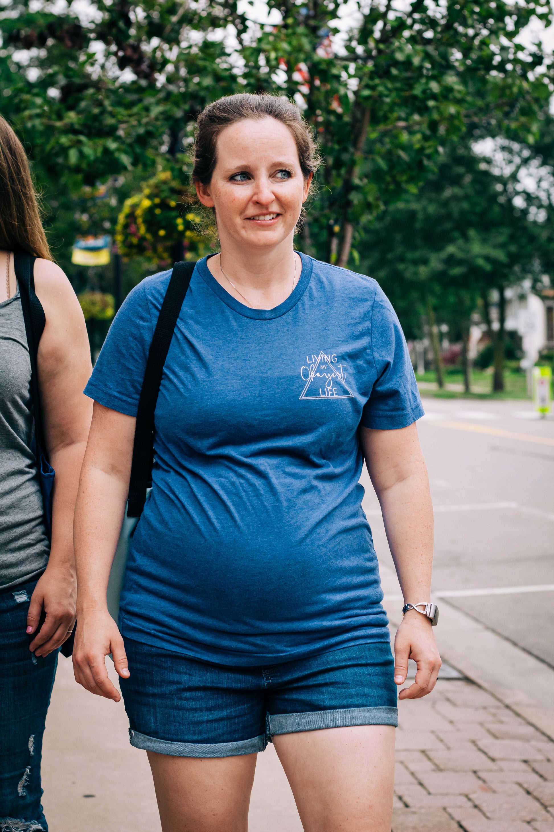Woman walking down the street with Okayest Life Blue T-Shirt